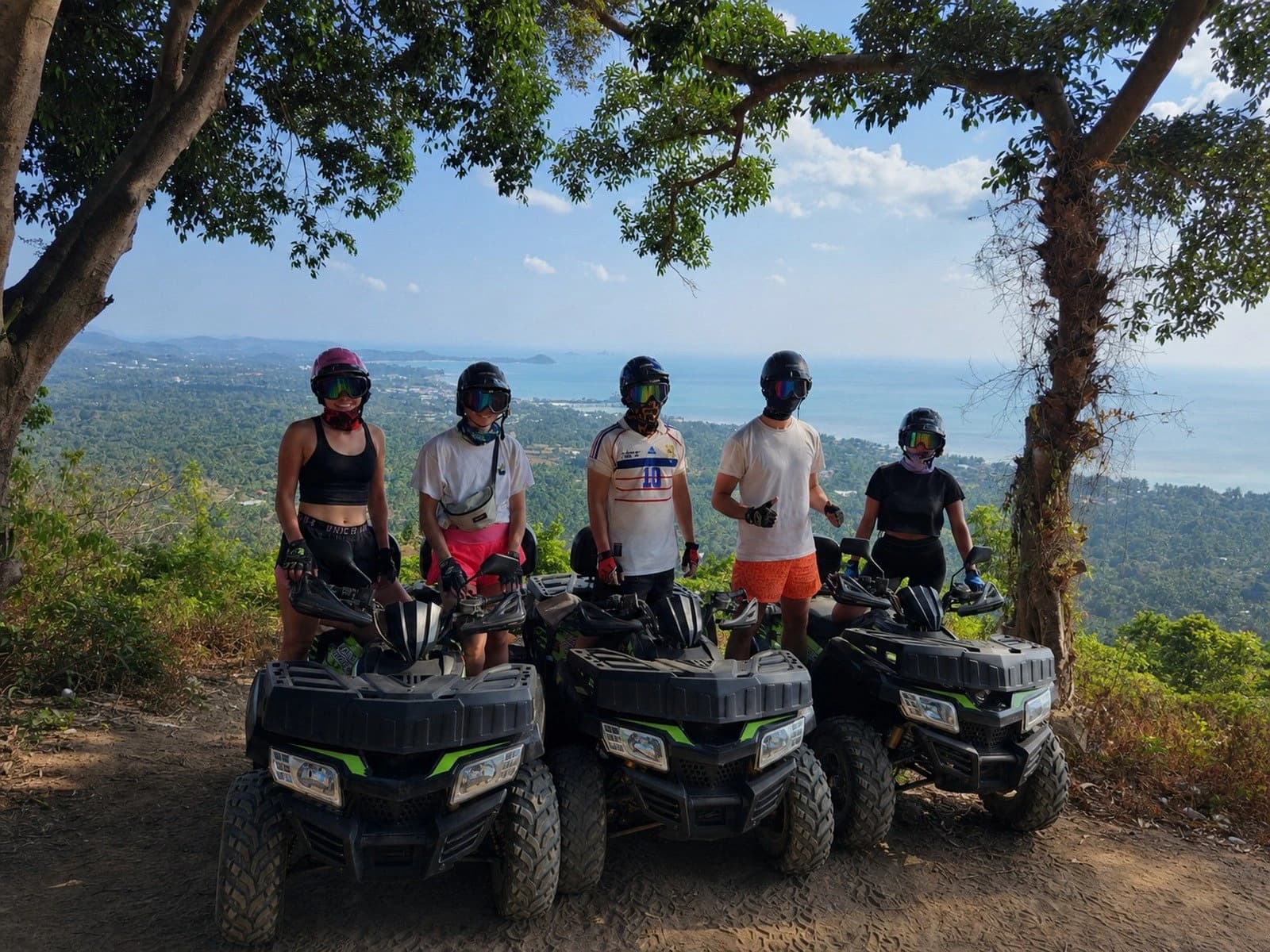 Wild Action Samui ATV group posing at a mountain viewpoint above the sea