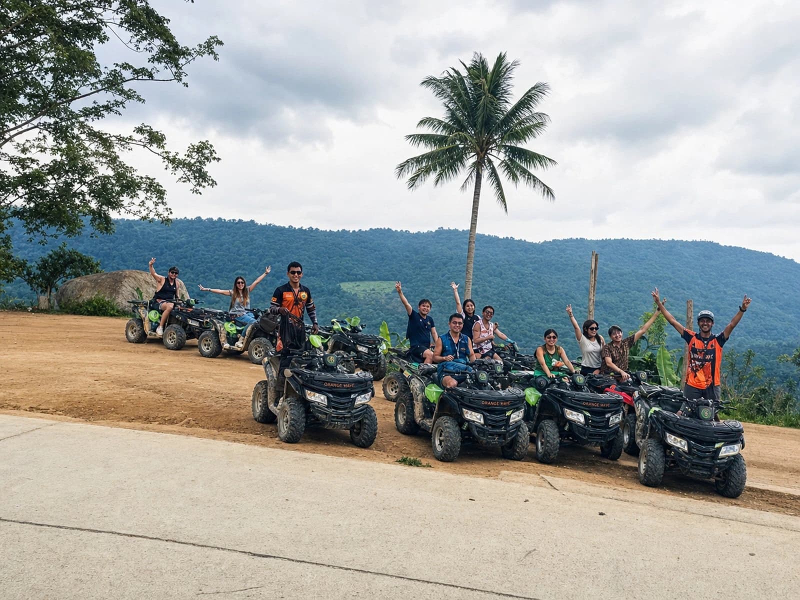 Orange Wave ATV tour group posing at mountain viewpoint